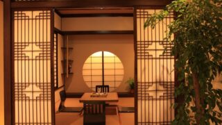 障子越しに見える畳敷きの和室と座卓、和風民宿の客室イメージ