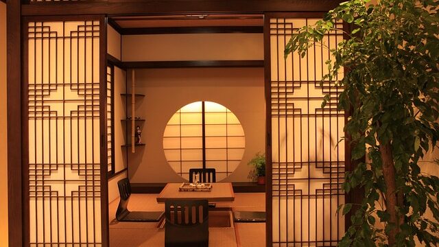障子越しに見える畳敷きの和室と座卓、和風民宿の客室イメージ